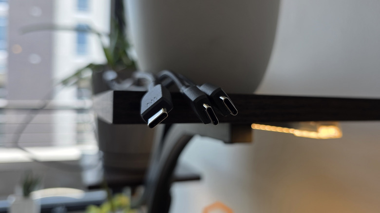 Ends of multiple USB-C cables dangling from a shelf