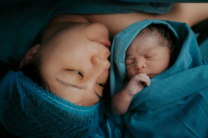 A woman with her newborn child. Photo by Pexels