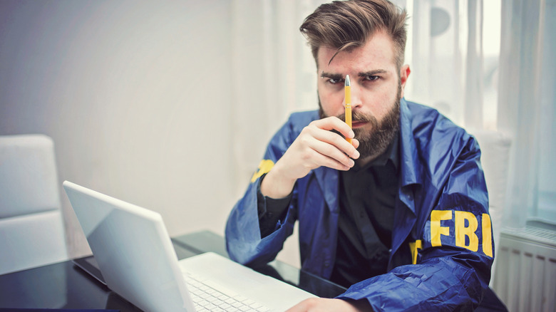 FBI agent scrutinizing a pen