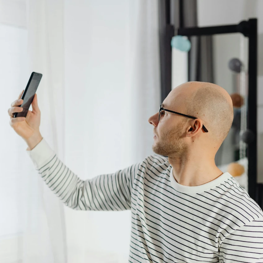 man taking picture to share on bald reddit
