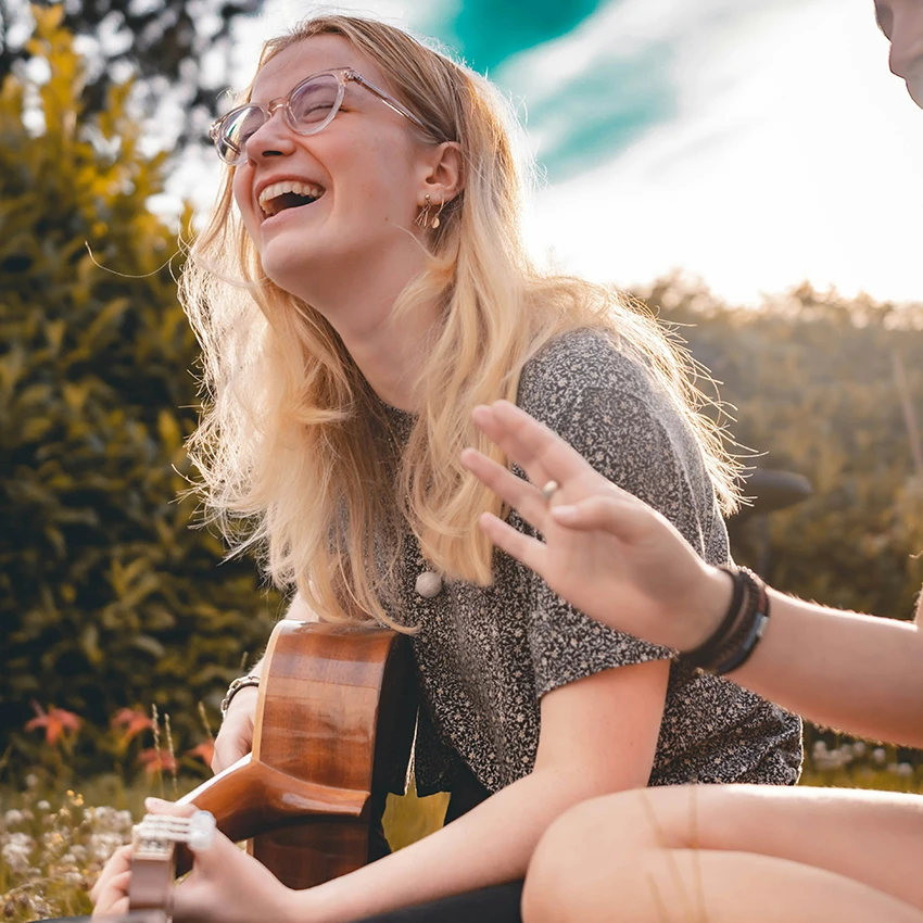 woman smiling playing guitar