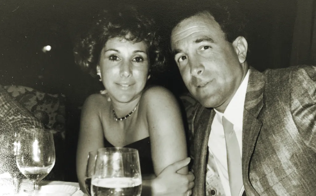 Black and white photo of a smiling couple in formal attire.