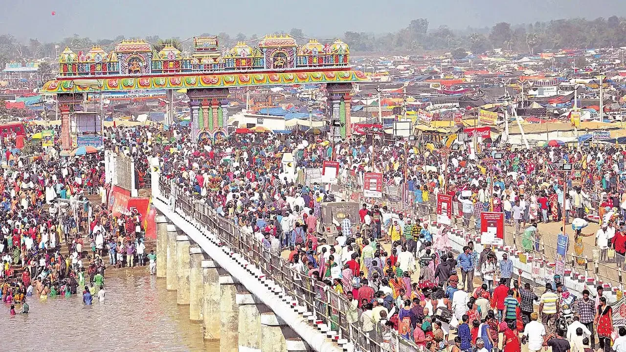 Massive crowd crossing a decorated bridge during a vibrant festival gathering in Telangana.