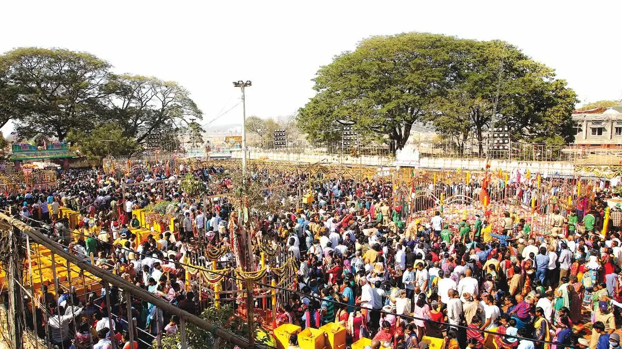 Huge crowd of devotees gathered at a colorful temple fair during a festival in Telangana.