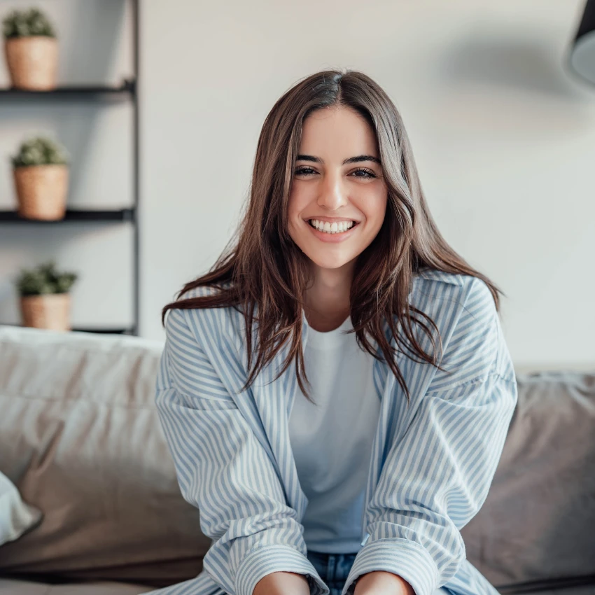 happy woman smiling sitting on couch at home
