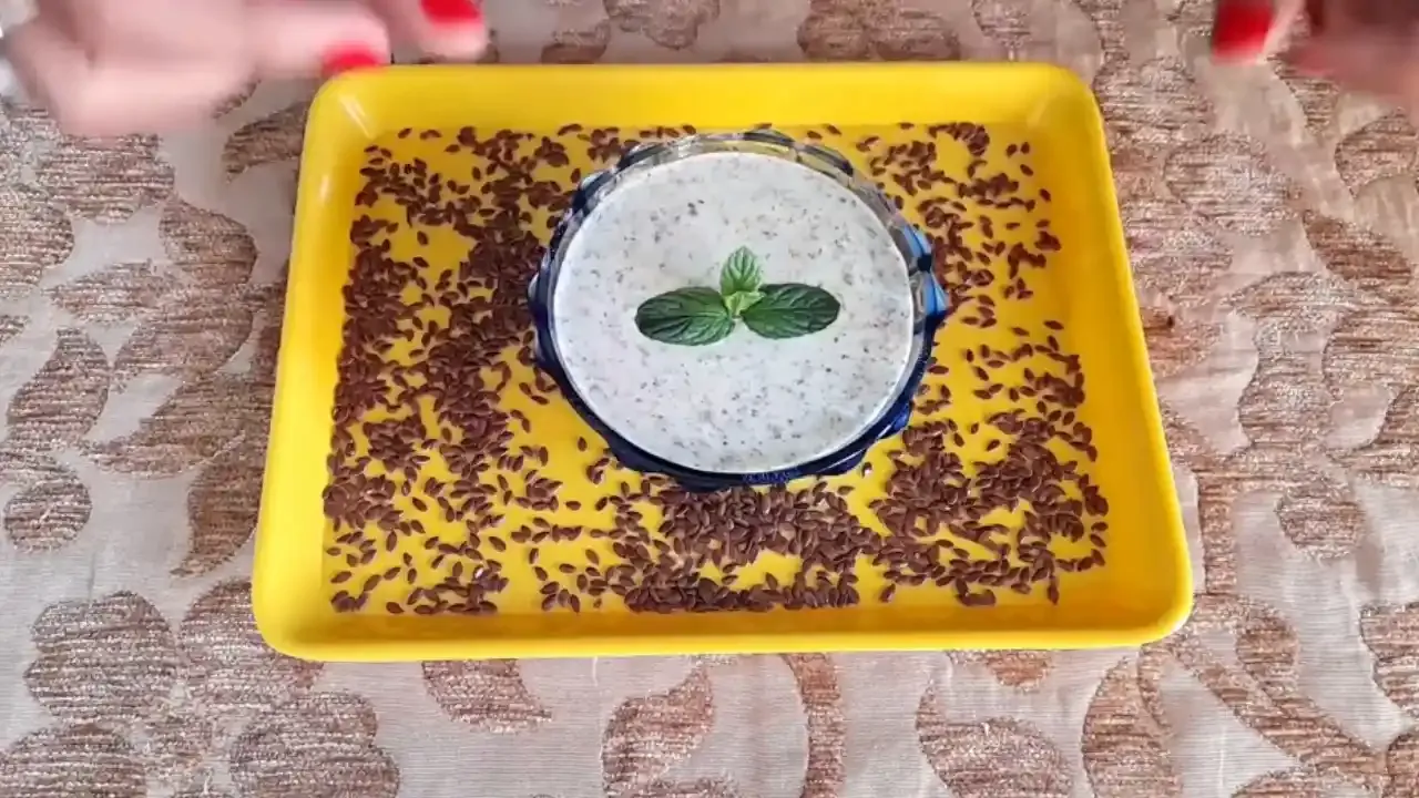 Nutrient rich flaxseed raita garnished with fresh mint leaves served in a glass bowl on a yellow tray.