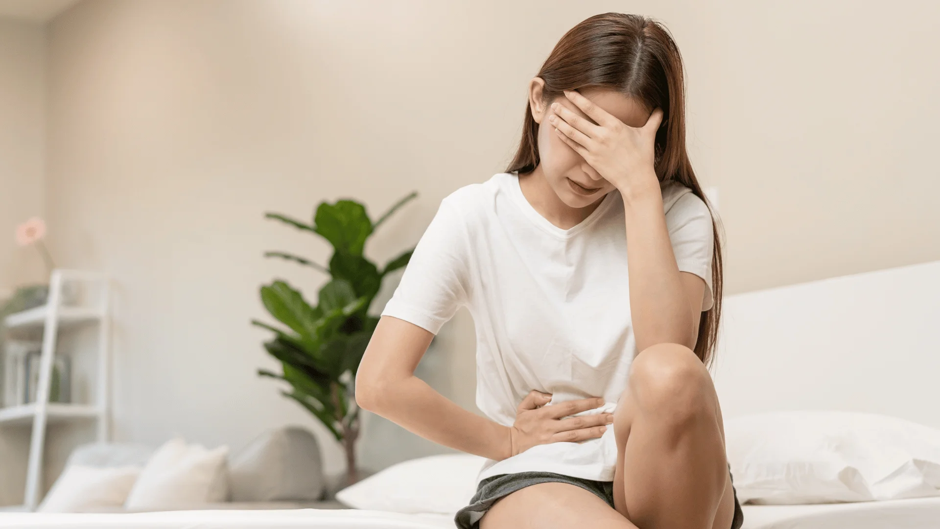 Woman whose body wants a break experiences a belly ache at home