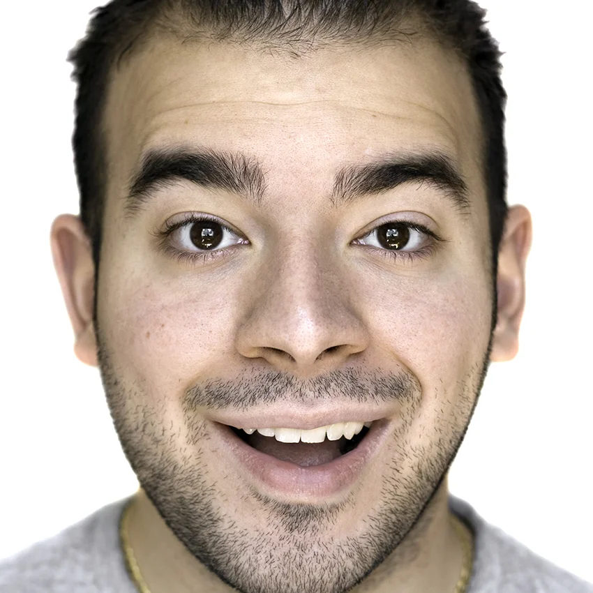 man with thick eyebrows smiling