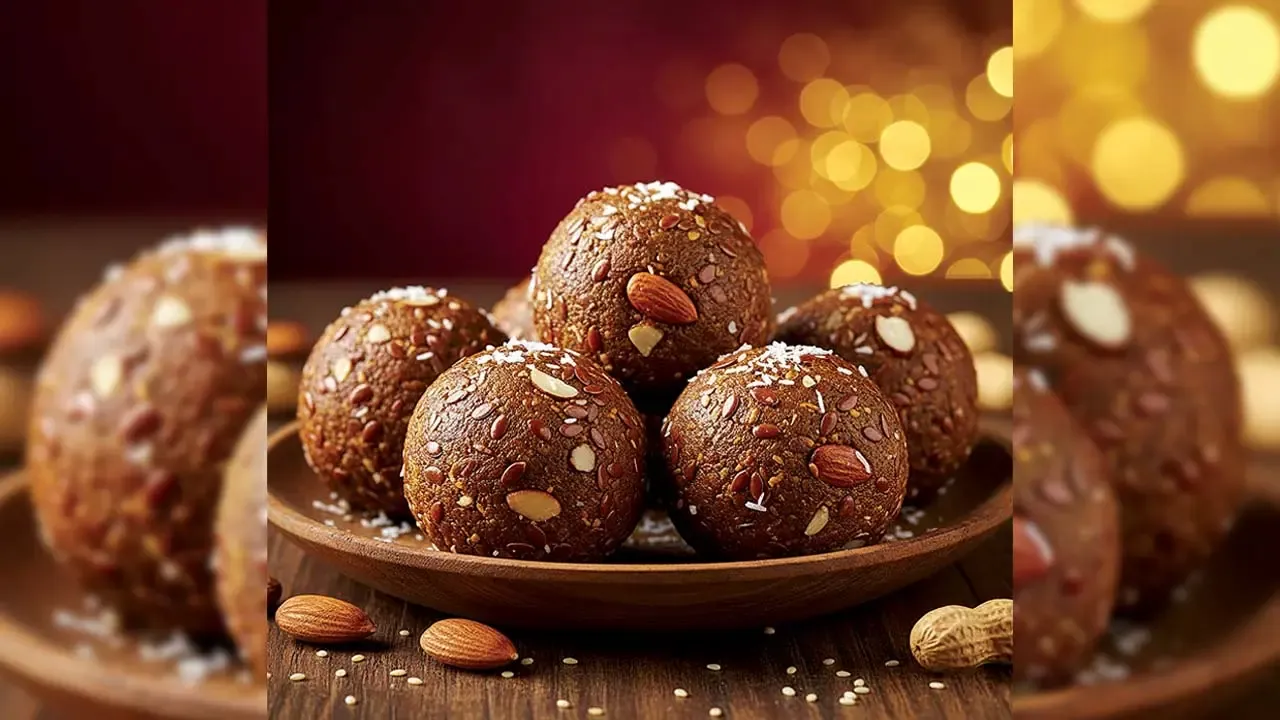 A close-up of a wooden plate filled with healthy energy pinnis or ladoos made of flaxseeds, almonds, and jaggery, topped with desiccated coconut, with a blurry golden polka background.