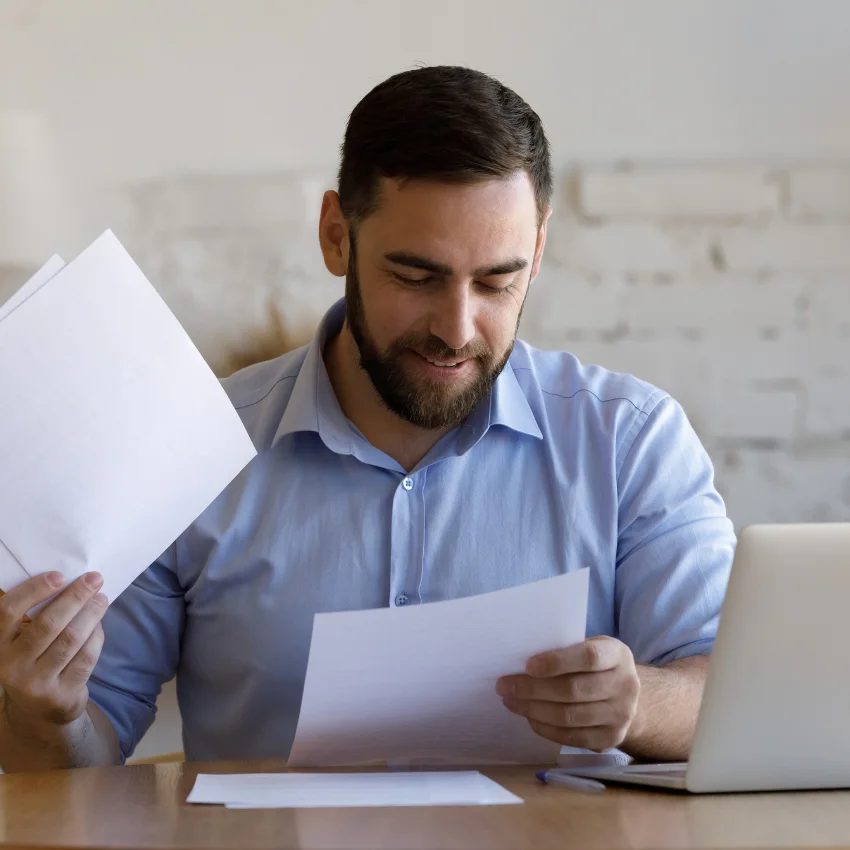 man happily paying his bills after negotiating them
