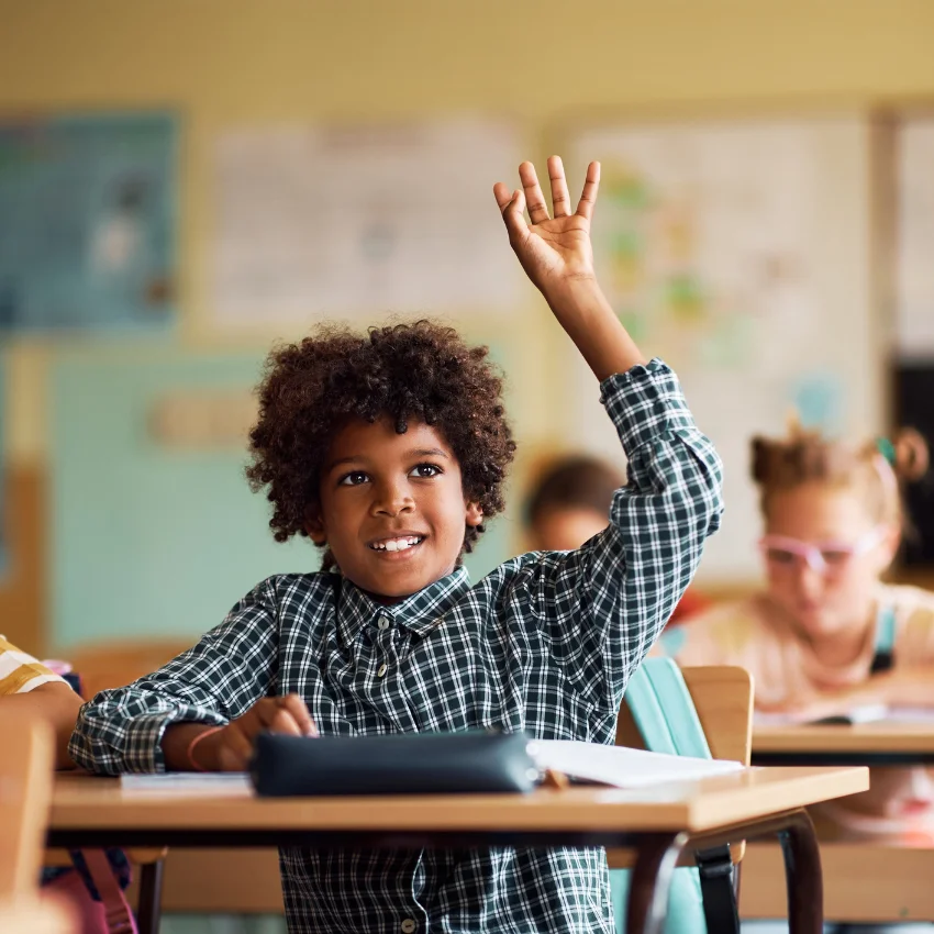 student raising his hands who has parents that don't protect him from hard things