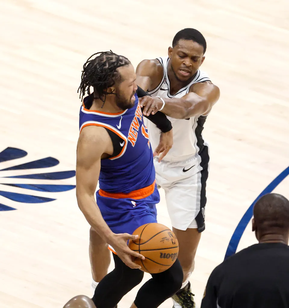 San Antonio Spurs guard De'aaron Fox fouls New York Knicks guard Jalen Brunson during the second half at Frost Bank Center.