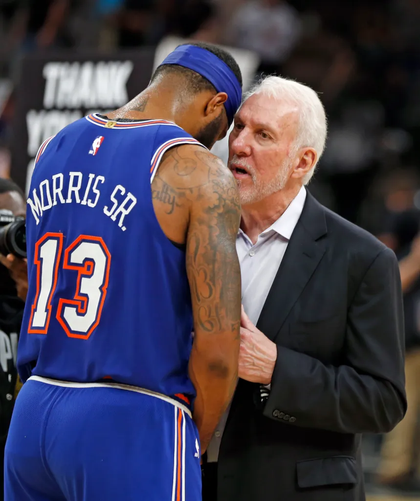 Basketball coach Gregg Popovich talking to player Marcus Morris Sr. during a game between the New York Knicks and the San Antonio Spurs.