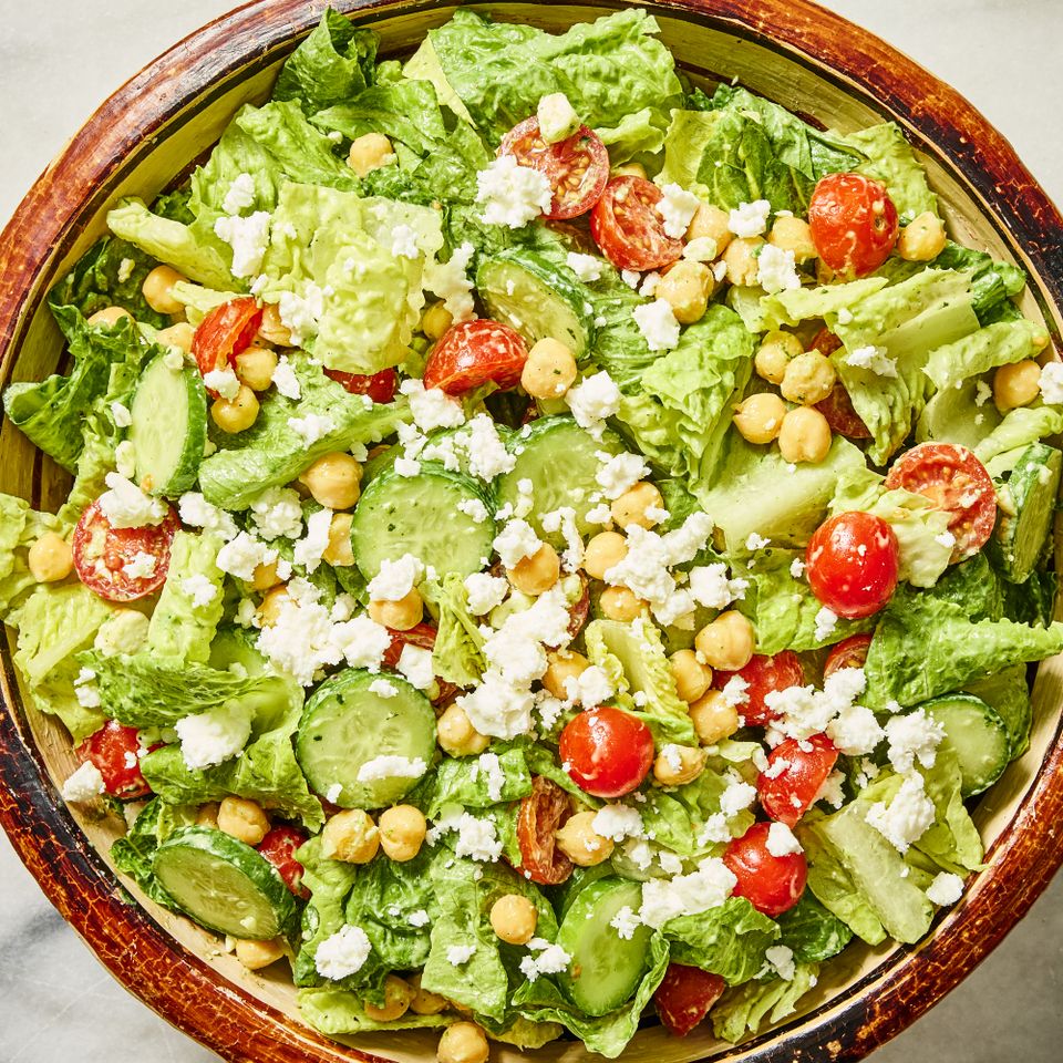 A salad consisting of lettuce cherry tomatoes cucumber slices chickpeas and crumbled cheese in a bowl Credit: Photographer: Morgan Hunt Ward, Food Stylist: Jennifer Wendorf, Prop Stylist: Joshua Hoggle