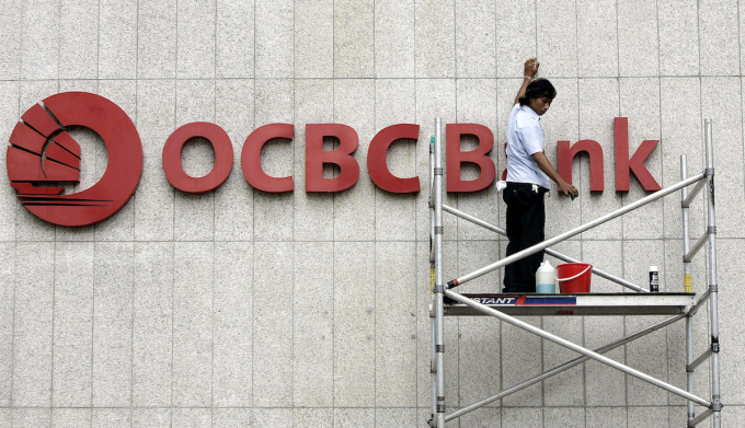 This file photo taken on June 28, 2005 shows a worker cleaning the OCBC bank logo in Singapore. Photo by AFP