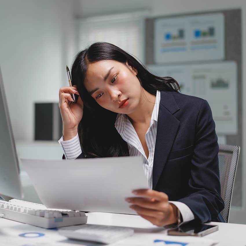 stressed businesswoman looking at paperwork