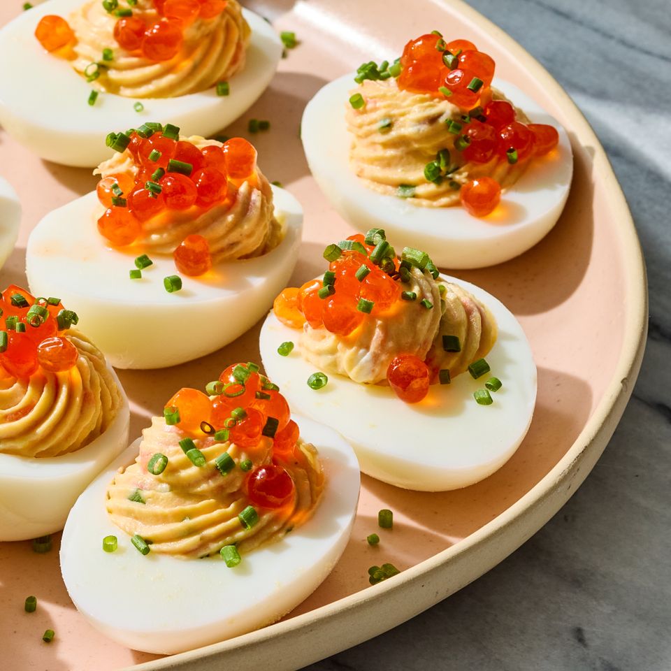 Deviled eggs garnished with smoked salmon chives and roe on a plate Credit: Photographer: Grant Webster, Food stylist: Annie Probst, Prop stylist: Kristen Schooley