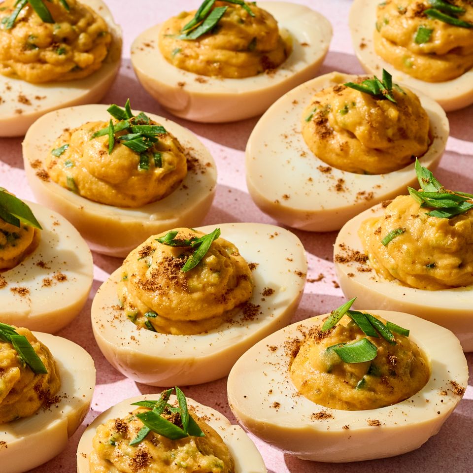 Deviled eggs garnished with chives and spices arranged on a surface Credit: Photographer: Grant Webster, Food stylist: Annie Probst, Prop stylist: Kristen Schooley
