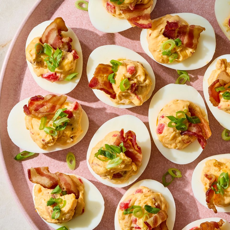 A plate of pimento cheesestuffed deviled eggs garnished with bacon and green onion Credit: Photographer: Grant Webster, Food stylist: Annie Probst,Prop stylist: Kristen Schooley