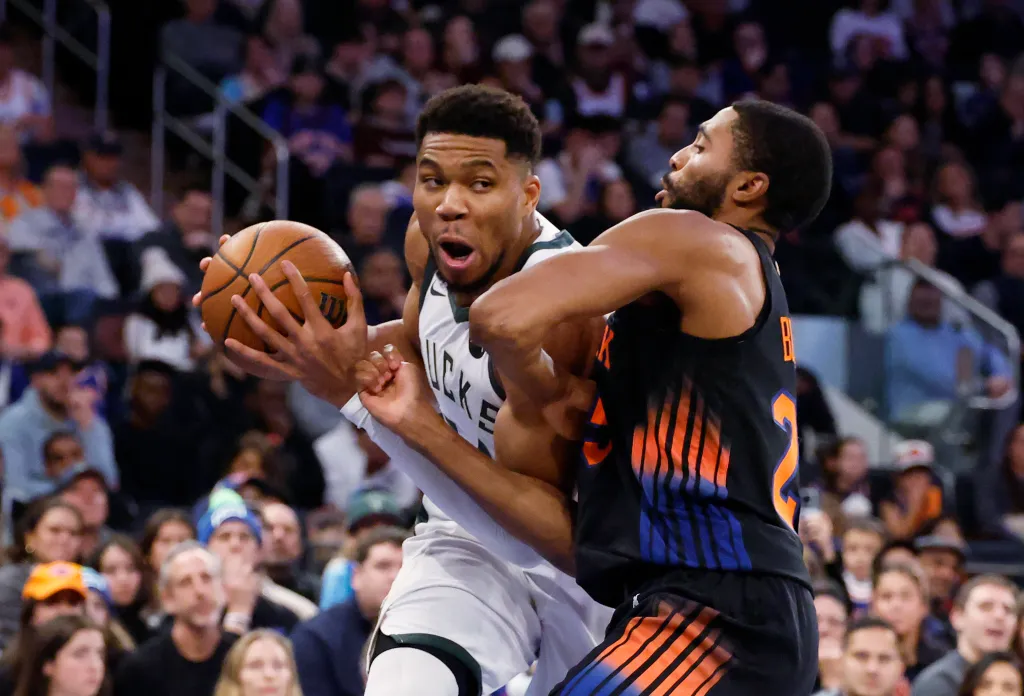 Giannis Antetokounmpo of the Milwaukee Bucks driving to the basket as Mikal Bridges of the New York Knicks defends.