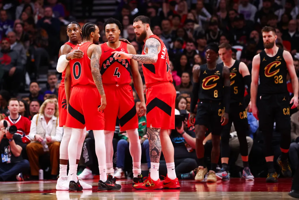 Toronto Raptors players huddle on the basketball court.
