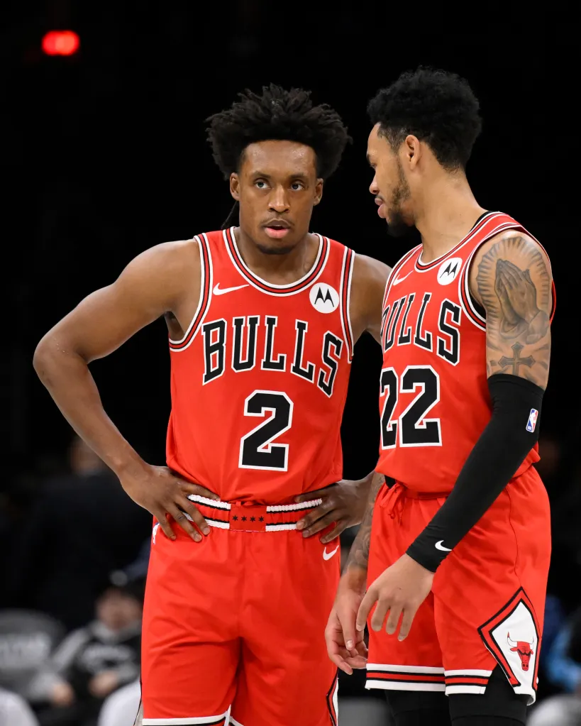Two Chicago Bulls basketball players in red uniforms on the court.