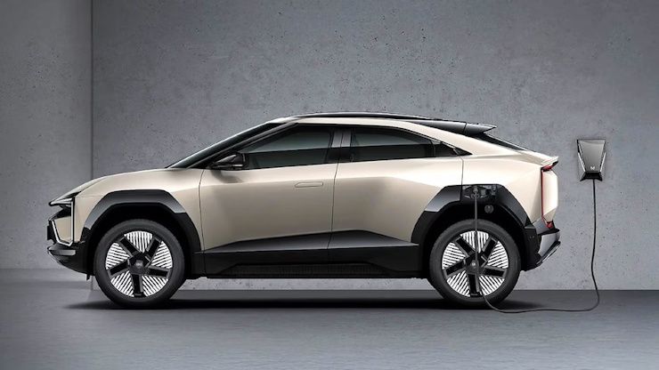 Mahindra Be 6 electric SUV charging against grey wall Mahindra Be 6 electric SUV charging against grey wall