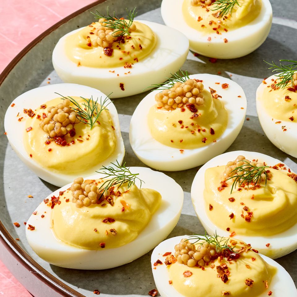 Platter of mustardtopped deviled eggs garnished with herbs and spices Credit: Photographer: Grant Webster, Food stylist: Annie Probst, Prop stylist: Kristen Schooley