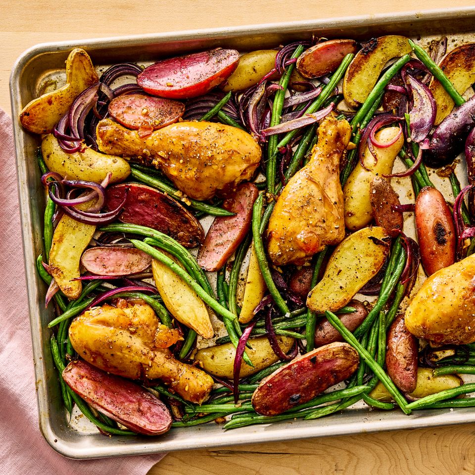 Sheet pan dish with roasted chicken drumsticks green beans purple onions and potatoes Credit: Photographer: Morgan Hunt Ward, Prop Stylist: Claire Spollen, Food Stylist: Margaret Monroe Dickey