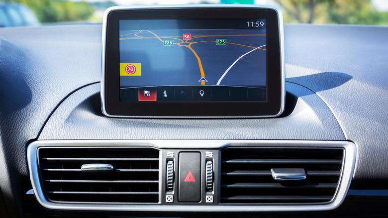 A media screen on the dashboard of a car showing navigation instructions