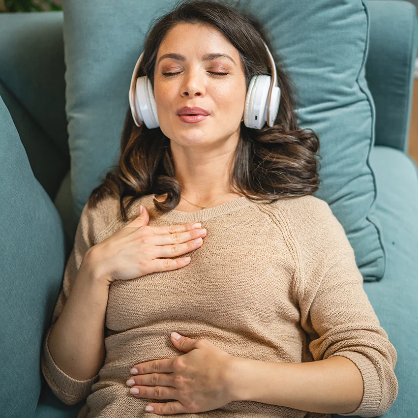 woman practicing meditation with headphones on