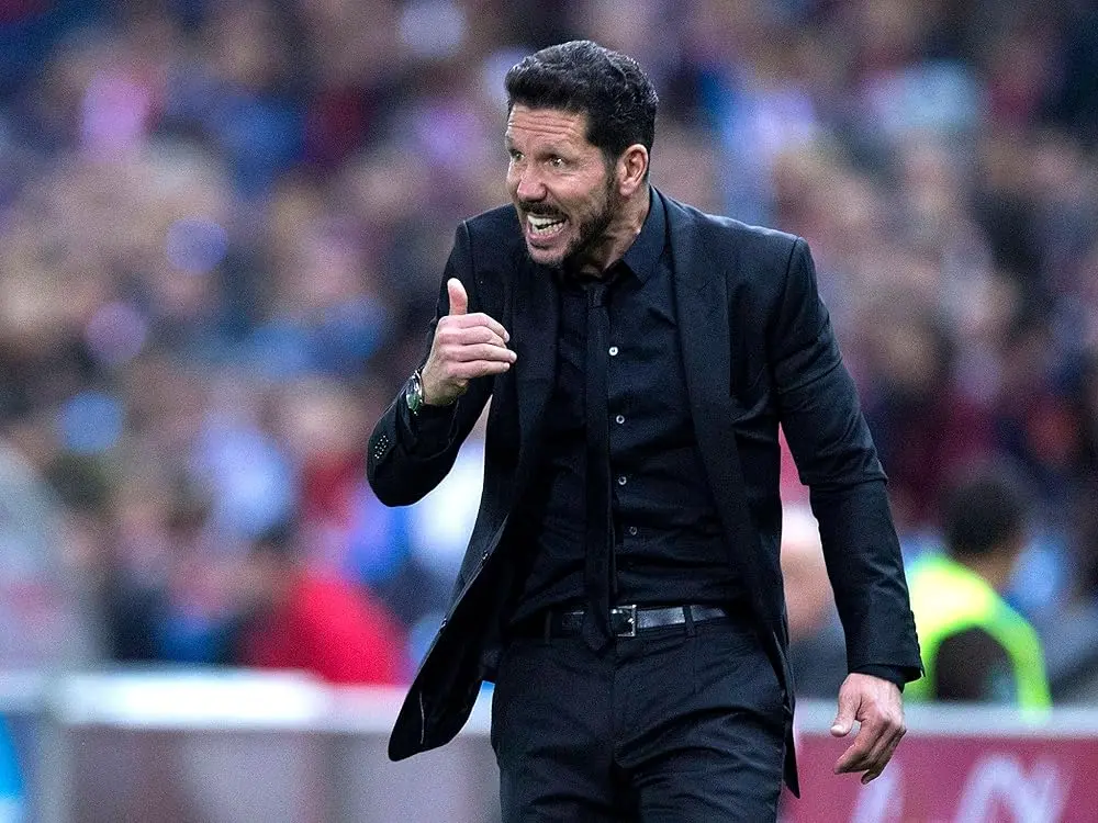 Diego Simeone gesturing as Atletico Madrid coach on the sidelines during a match.