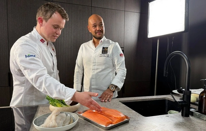 Espeland (L) and Christian Karlsson prepare salmon before a meal for the Norway national team at the 2026 World Cup. Photo by Norwegian Seafood Council