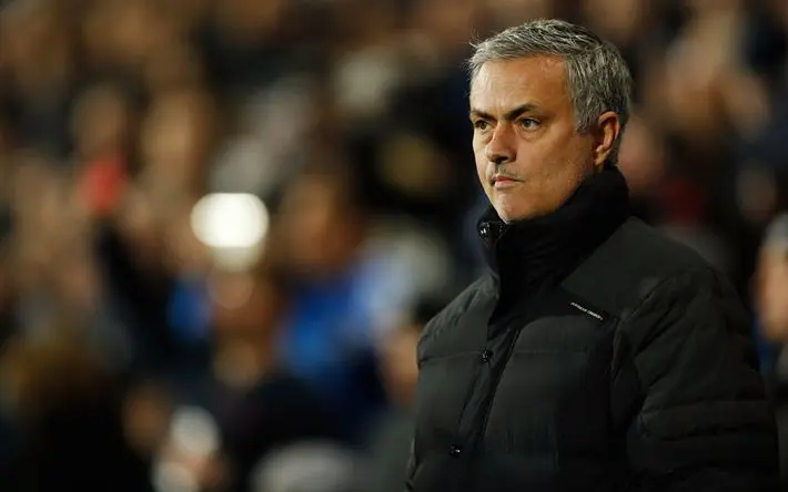 Jose Mourinho stands on the sidelines during a match, looking contemplative.