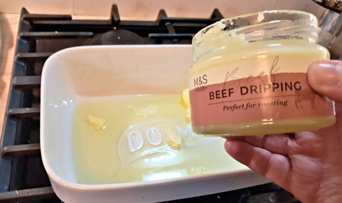 Picture of beef dripping being added to a hot tray 