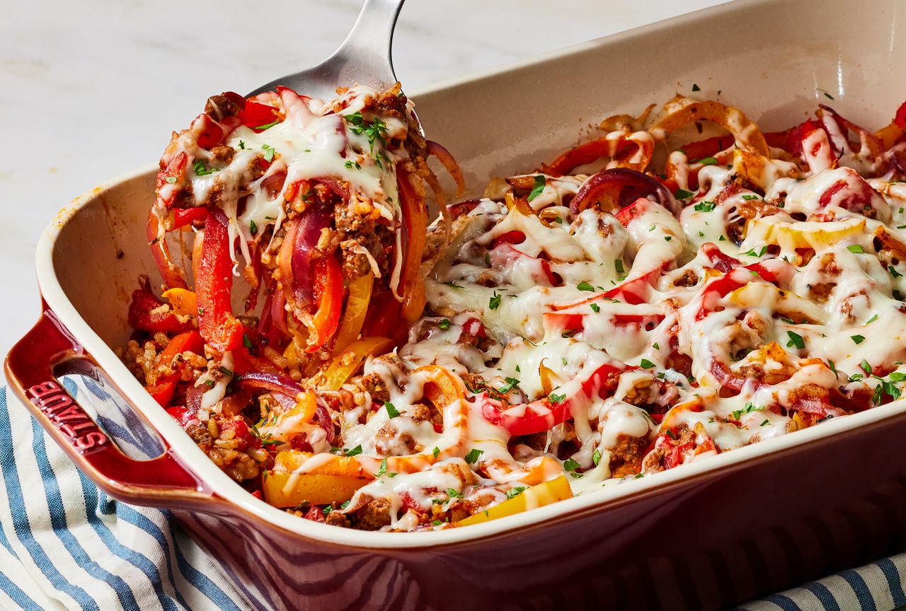 Stuffed Pepper Casserole being lifted out of casserole dish with serving spoon Credit: Photographer Victor Protasio, Food Stylist Jennifer Wendorf, Prop Stylist Julia Bayless