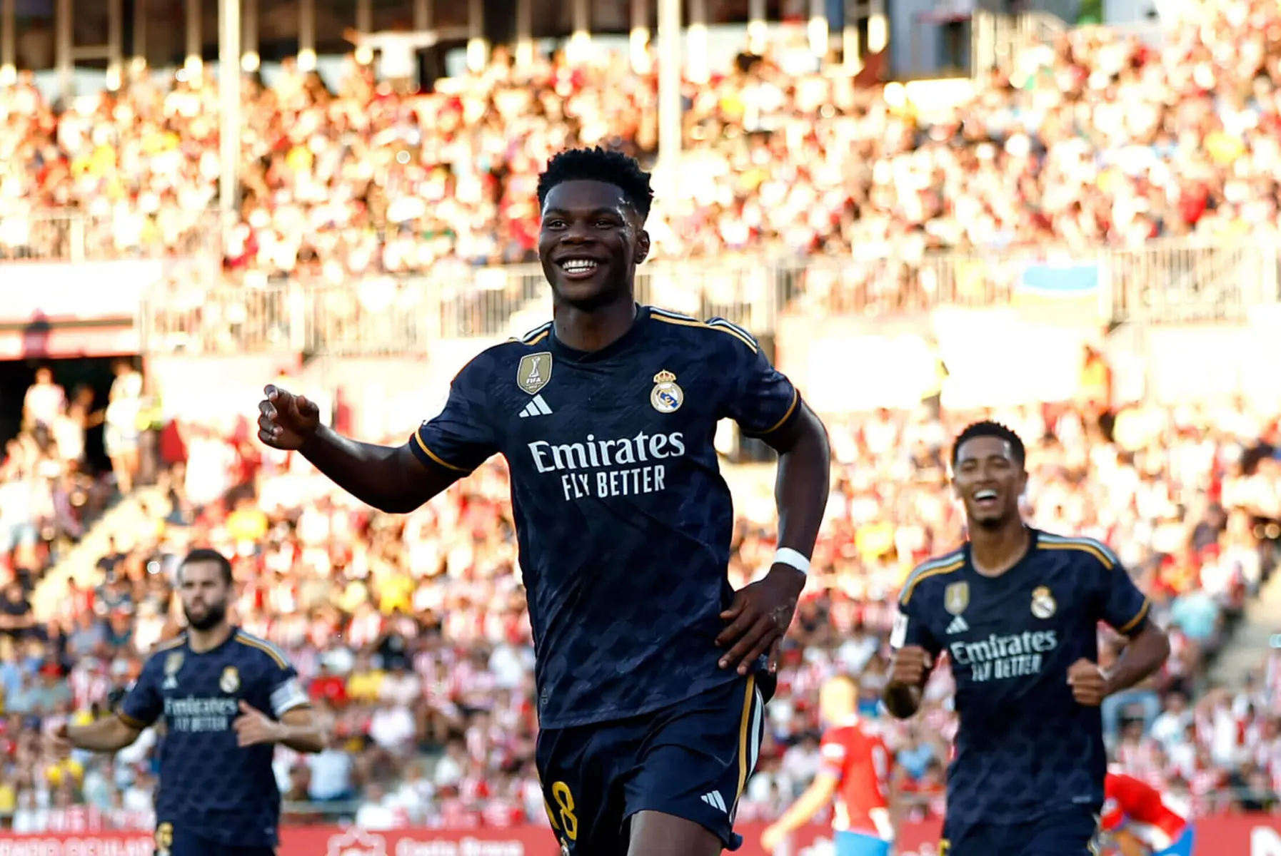Aurelien Tchouameni smiling in a dark blue Real Madrid kit during a football match
