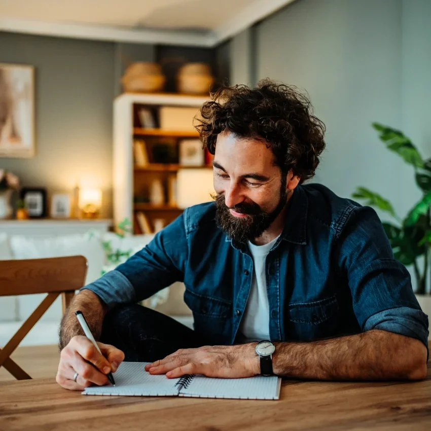 overwhelmed man writing in a journal to expel his chaotic thoughts