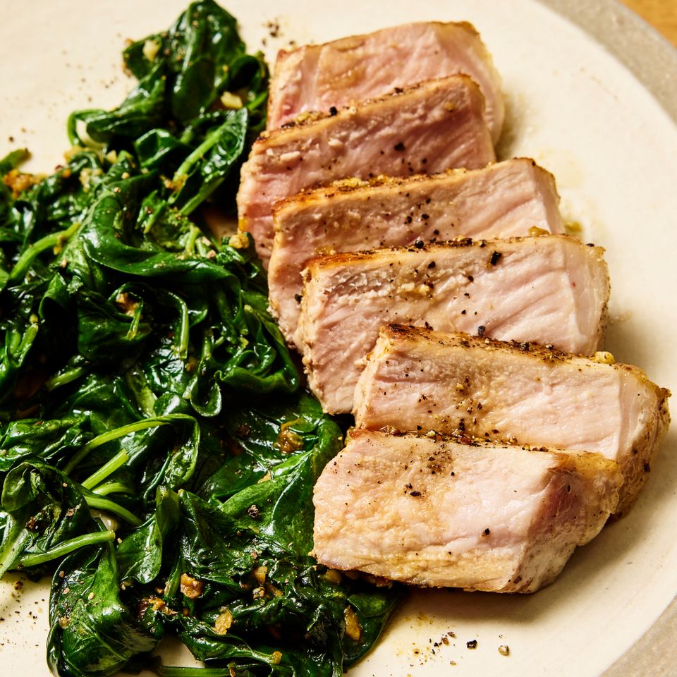 Sliced pork chops with a side of sauted spinach on a plate Credit: Photographer: Morgan Hunt Ward, Prop Stylist: Priscilla Montiel, Food Stylist: Chelsea Zimmer.