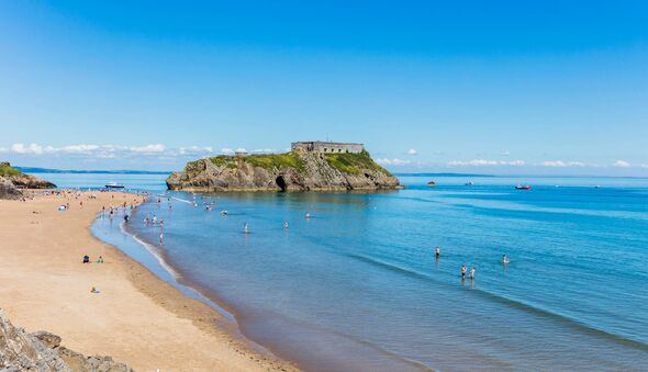 View of Tenby coastline with St Catherine's Island as the focal point. The sky and sea is blue and inviting. You can see people View of Tenby coastline with St Catherine's Island as the focal point. The sky and sea is blue and inviting. You can see people