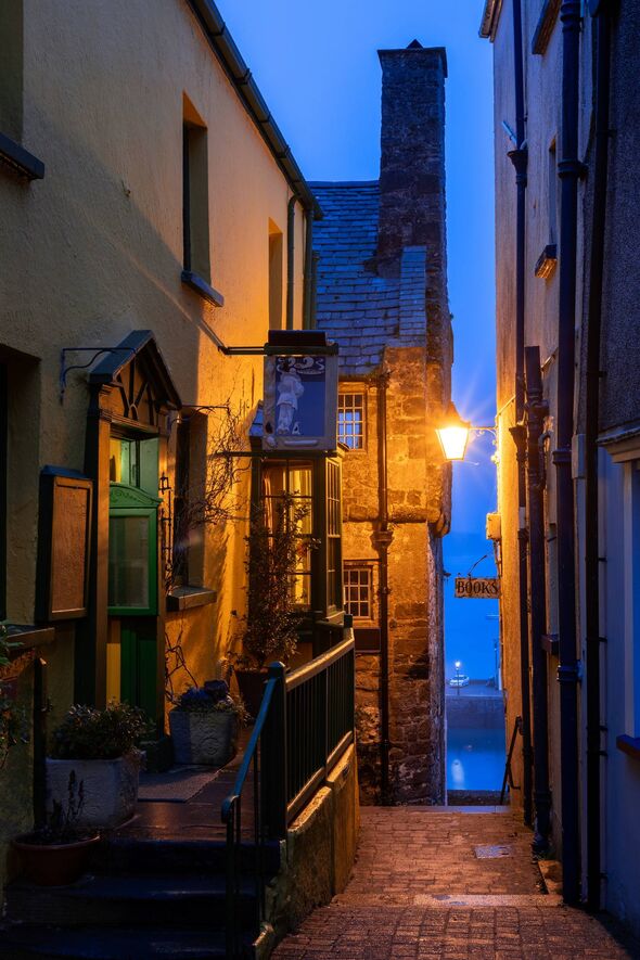 Tudor Merchant's House (with chimney), Quay Hill, Tenby, Pembrokeshire, Wales. Looking towards the harbour, early morning. Tudor Merchant's House (with chimney), Quay Hill, Tenby, Pembrokeshire, Wales. Looking towards the harbour, early morning.