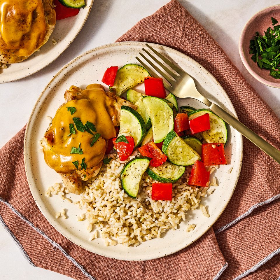 Plate of honey mustard chicken zucchini red peppers and rice with a fork placed on a napkin Credit: Ali Redmond