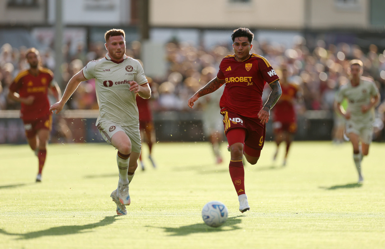 NEWPORT, WALES - AUGUST 04: Santiago Castro of AS Roma runs with ball under pressure from Lee Jenkins of Newport County during the pre-season friendly match between Newport County and AS Roma at Rodney Parade on August 04, 2026 in Newport, Wales. (Photo by Dan Istitene/Getty Images)