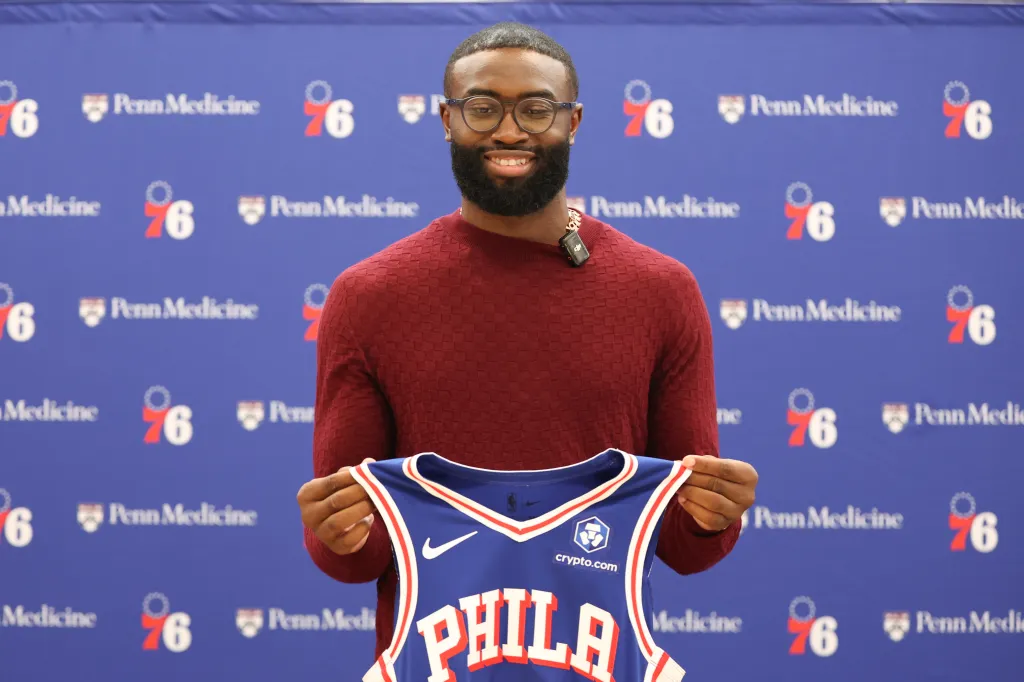 Jaylen Brown holding up a Philadelphia 76ers jersey at his introductory press conference.