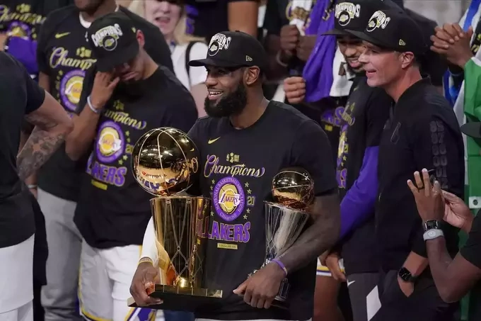 LeBron James (C) holds the NBA trophies and celebrates with his teammates after the Los Angeles Lakers defeated the Miami Heat 106-93 in Game 6 of the NBA Finals at Lake Buena Vista, Florida on Oct. 11, 2020. Photo by AP