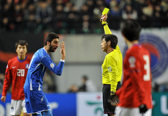 Referee Yuichi Nishimura (R) shows a yellow card to Fahed Al Ebrahim during South Koreas 2-0 victory over Kuwait in the 2014 World Cup qualifiers at Seoul World Cup Stadium on Feb. 29, 2012. Photo by AFP