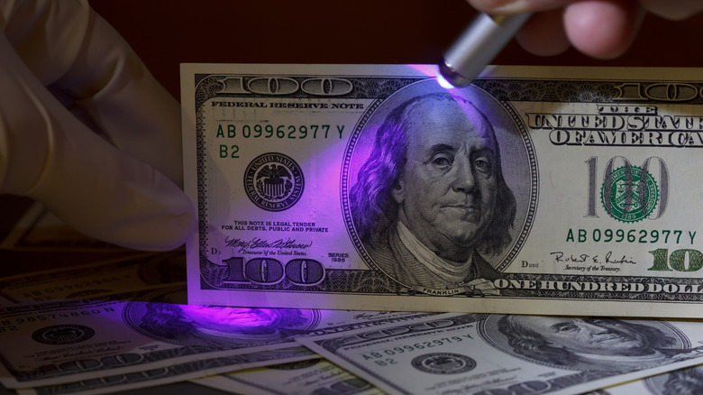 Checking a $100 bill with a UV light