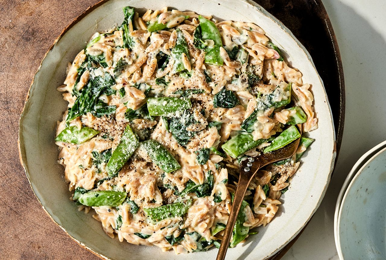 Overhead view of a plate of Creamy Lemon Orzo with Spinach & Snap Peas recipe Credit: Photographer: Jen Causey, Food Stylist: Ruth Blackburn
