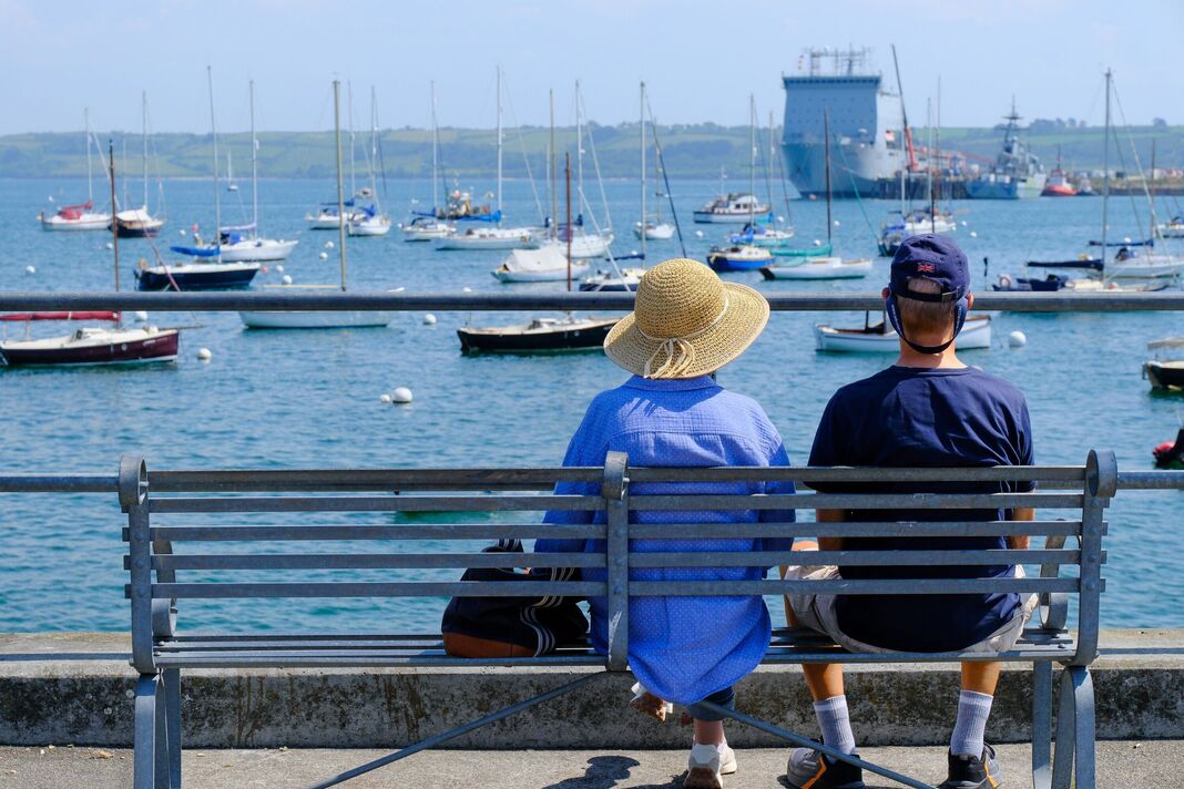A middle aged couple on holiday in Falmouth looking over the bay to the coastal view