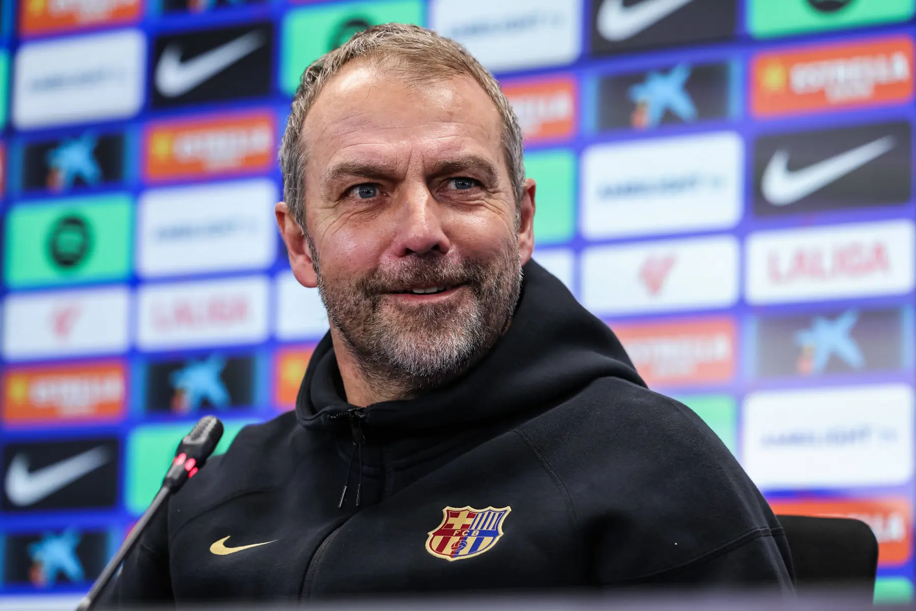 Hansi Flick wearing a black FC Barcelona hoodie during a press conference
